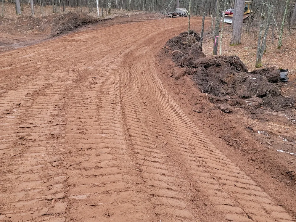 New road base curving through the woods, driveway and road building